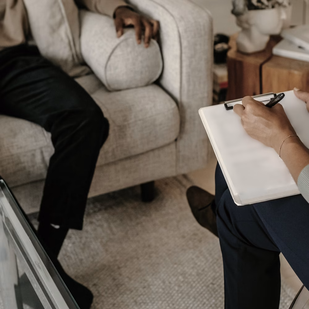 Therapist taking notes on a clipboard during a session