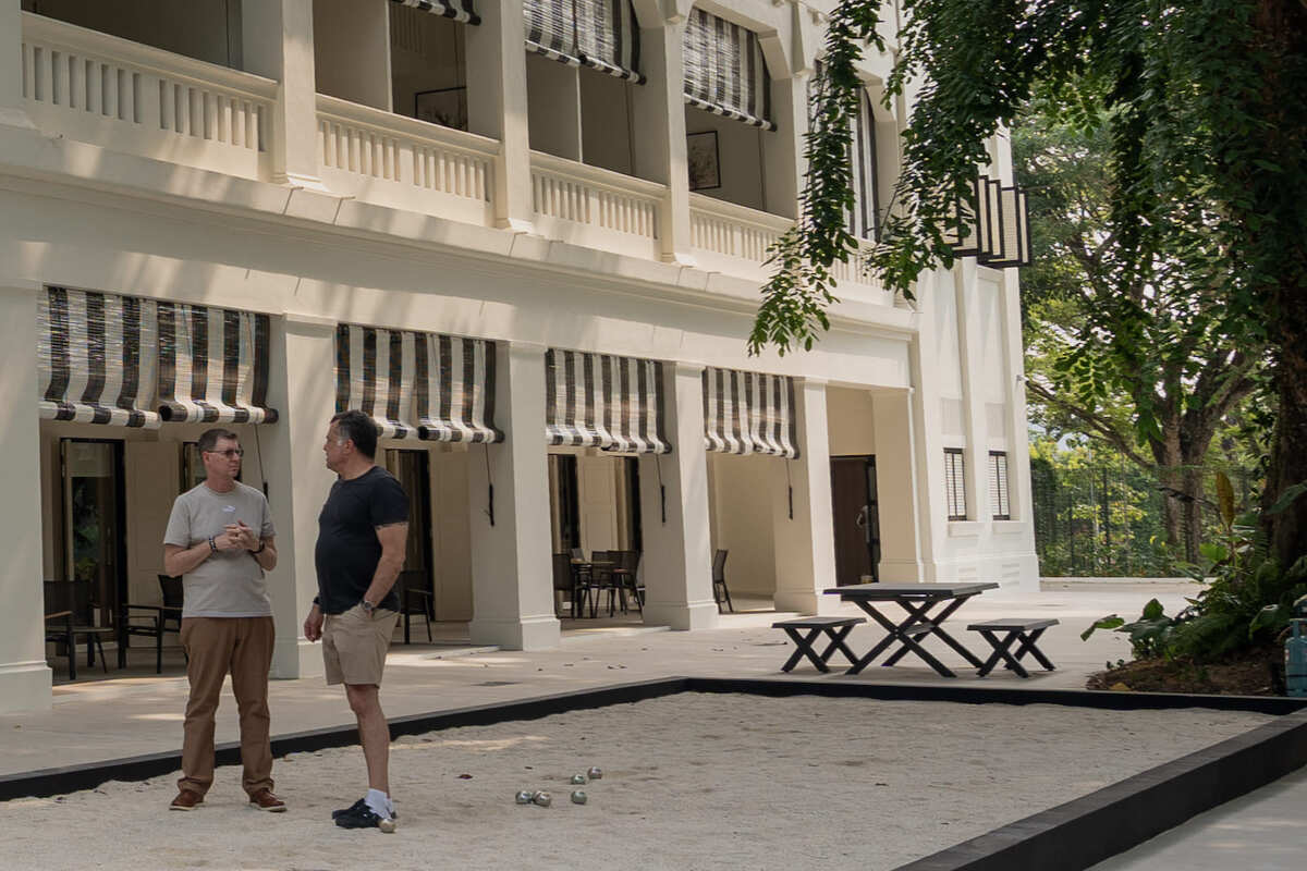 Exterior of The Winslow's colonial building with petanque court and outdoor seating