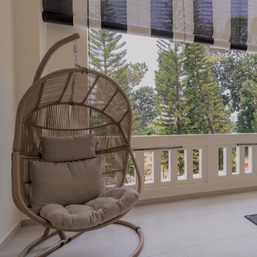 Hanging rattan chair on balcony of Sanctuary Single room overlooking trees
