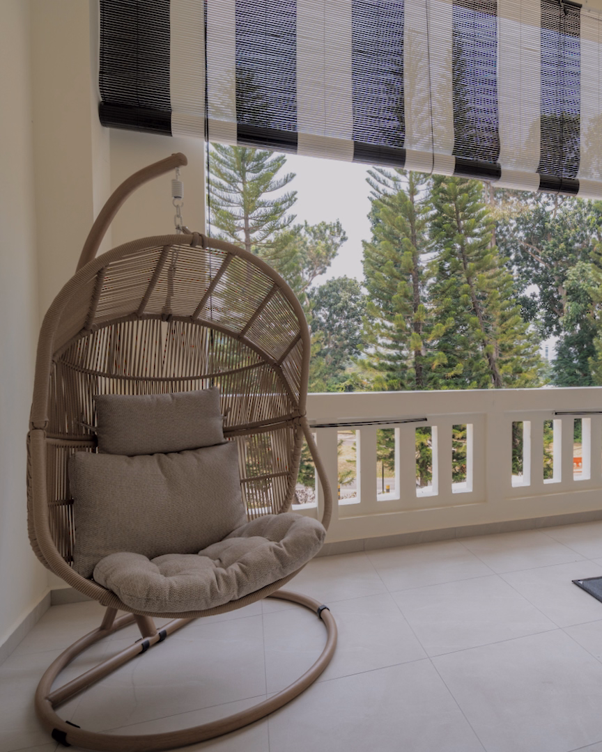 Hanging rattan chair on balcony of Sanctuary Single room overlooking trees