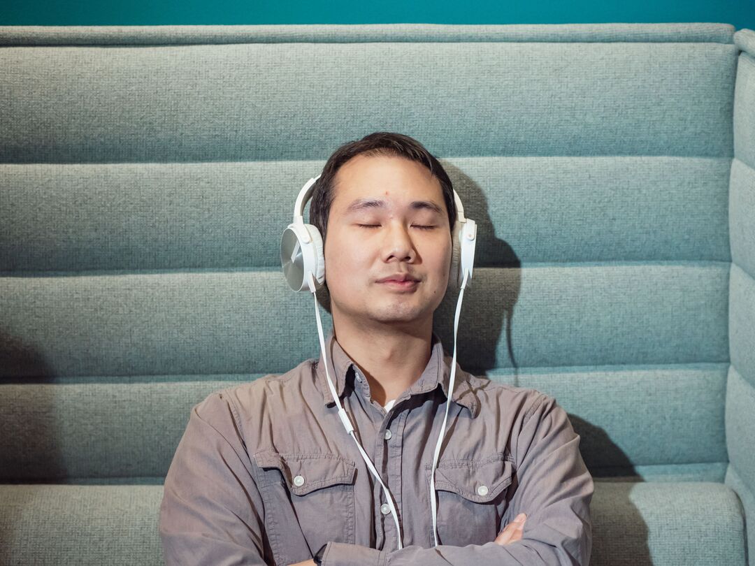 Man with eyes closed listening through headphones