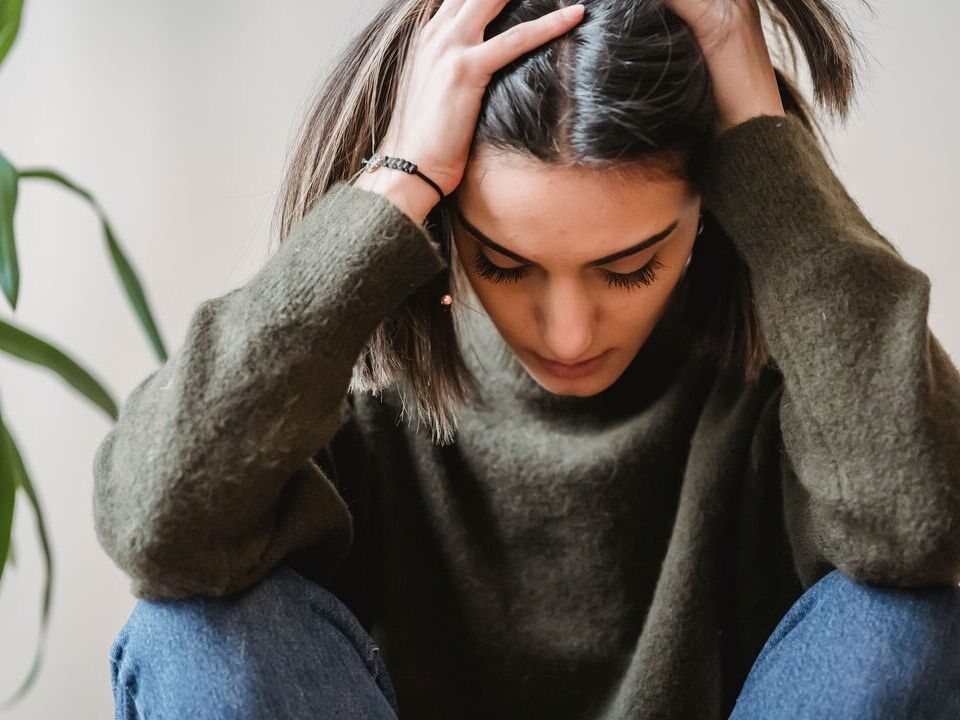 Woman sitting with her head in her hands